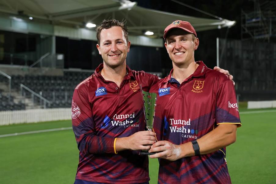 Two men in sports uniforms holding a trophy

Description automatically generated